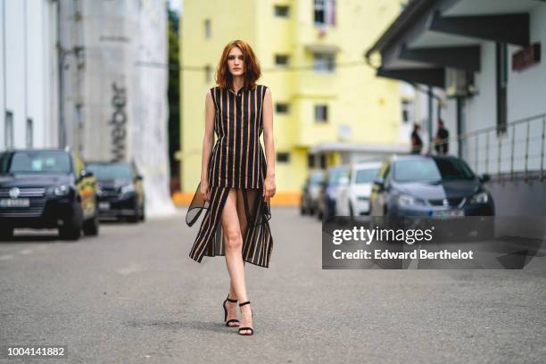 Dariana Cerciu wears a striped sleeveless dress with black lace, black heels shoes, during Feeric Fashion Week 2018, on July 22, 2018 in Sibiu,...