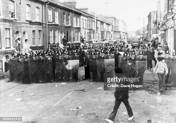 Police take action in the streets of Brixton during the Brixton riots in London, 1981.