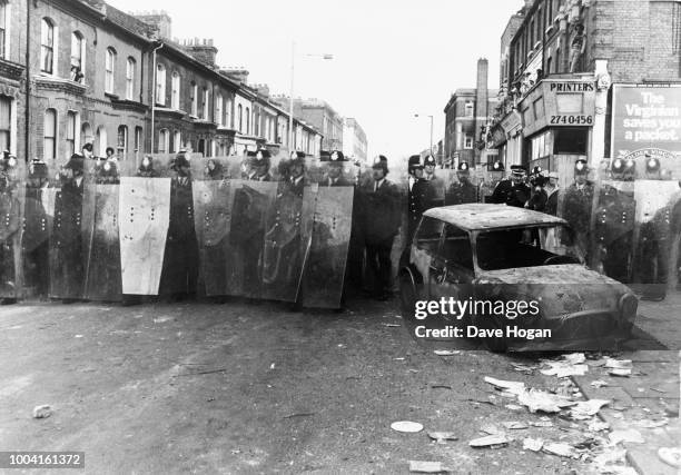 Police take action in the streets of Brixton during the Brixton riots in London, 1981.