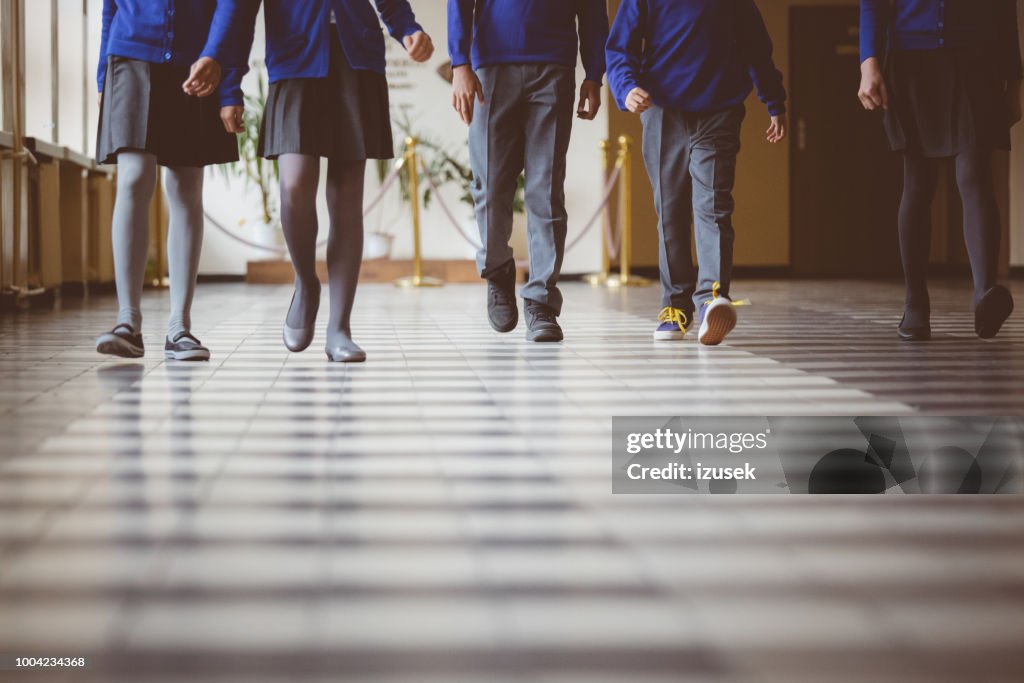 Grupo de estudiantes caminando por el pasillo de la escuela