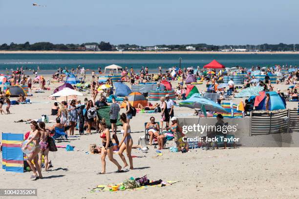 Beachgoers gather on West Wittering Beach during hot weather on the first day of the Summer school holidays on July 23, 2018 in Chichester, England....