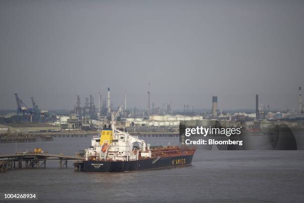 Chemical and oil tanker ship Cielo Di Ulsan, operated by D'Amico Tankers DAC, sits moored at a jetty as silos stand on a chemical plant beyond near...