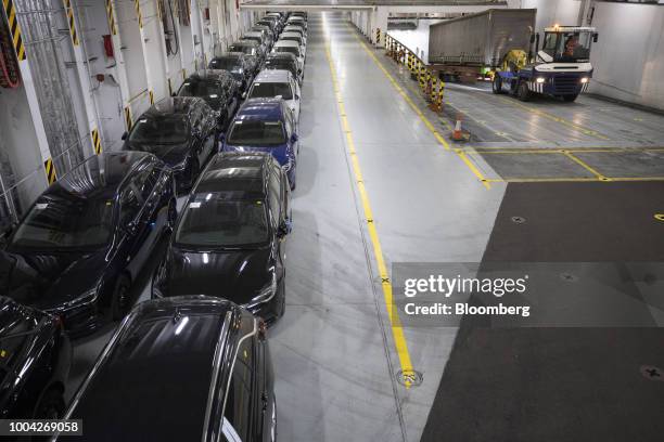 New Adam Opel AG Insignia automobiles sit parked as cargo truck trailer is driven up a ramp on board roll-on roll-off vessel Delphine, operated by...