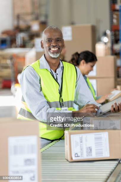 cheerful distribution warehouse manager - boxes conveyor belt stock pictures, royalty-free photos & images