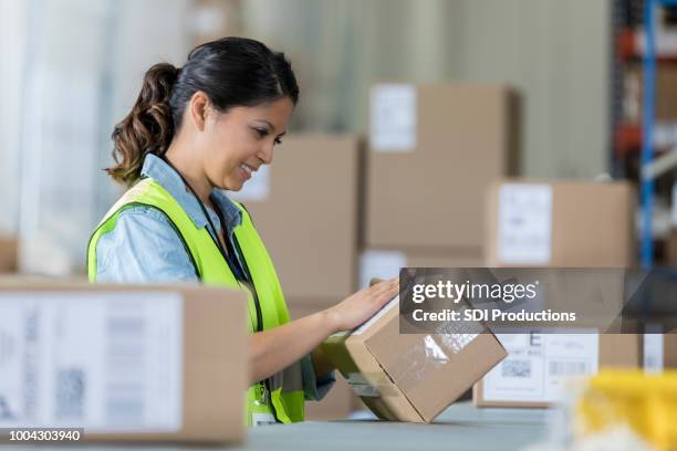 distribution warehouse employee prepares package - mailroom stock pictures, royalty-free photos & images