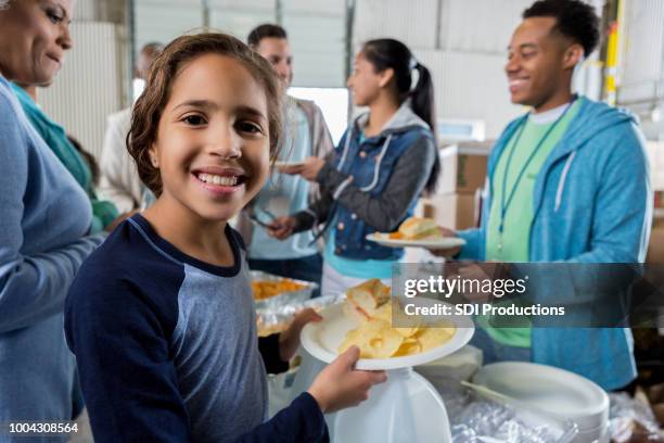 niña recibe comida durante la colecta de caridad de banco de alimentos - centro de acogida a personas sin hogar fotografías e imágenes de stock