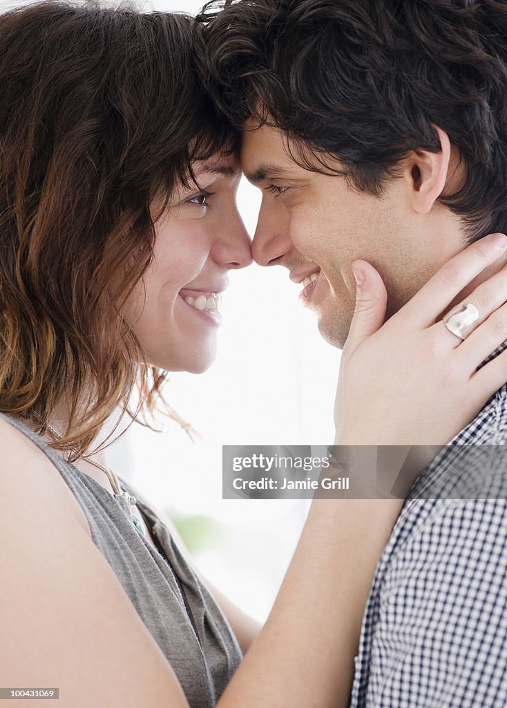 Young couple embracing and smiling at one another