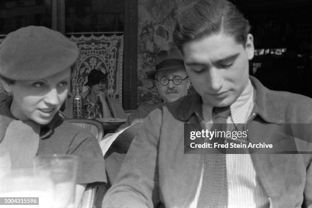 View of German photographer Gerda Taro and Hungarian photographer Robert Capa as they sit togather at a sidewalk cafe, Paris, France, 1936. Other,...