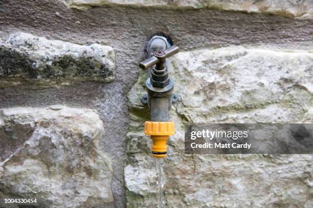 In this photo illustration water runs from an outside water tap in a garden in the village of Priston on July 23, 2018 near Bath, England. Seven...