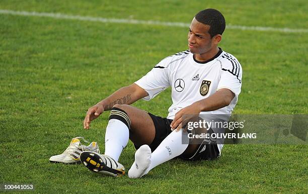 Germany's defender Dennis Aogo sits on the pitch during a training match Germany vs Sued Tyrol FC at the team's training centre in Appiano, near the...