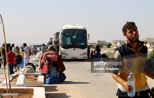 Syrian civilians are seen with their belongings after third convoy carrying opposition fighters and civilians set out from Syrias southwestern Daraa...