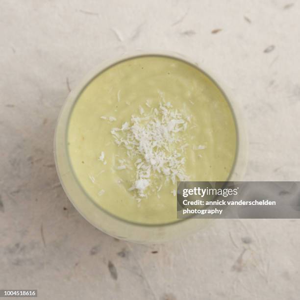 avocado smoothie with coconut garnish - avocado smoothie stock pictures, royalty-free photos & images