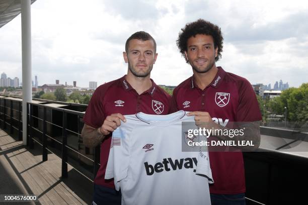 West Ham United's Brazlian midfielder Felipe Anderson and West Ham United's English midfielder Jack Wilshere pose with team jerseys during a...