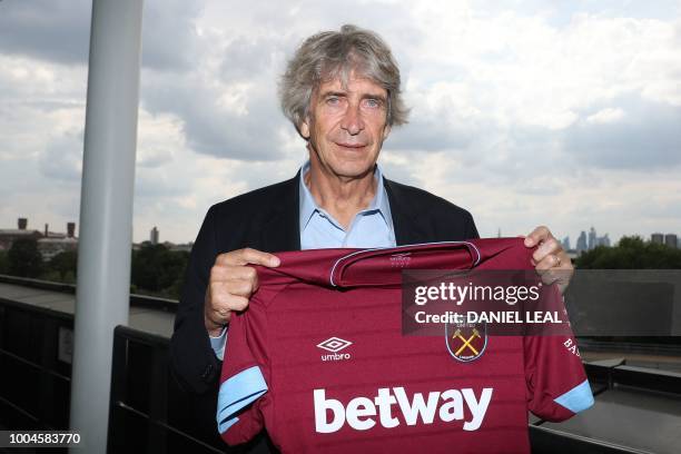 West Ham United's Chilean manager Manuel Pellegrini poses with a team jersey during a photocall for the unveiling of the club's new manager and newly...