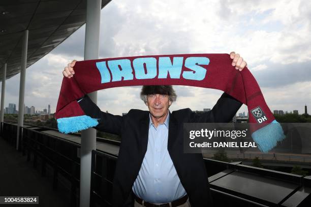 West Ham United's Chilean manager Manuel Pellegrini poses with a scarf in the team colours during a photocall for the unveiling of the club's new...