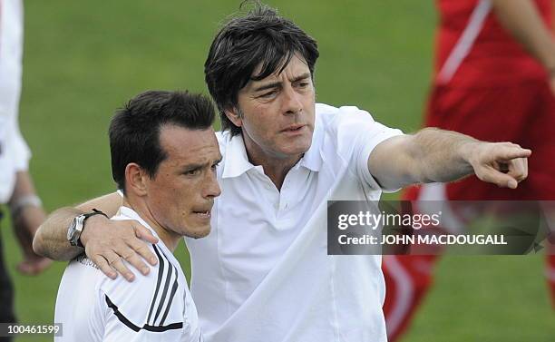 Germany's head coach Joachim Loew speaks to Germany's midfielder Piotr Trochowski following a training match Germany vs Sued Tyrol FC at the team's...