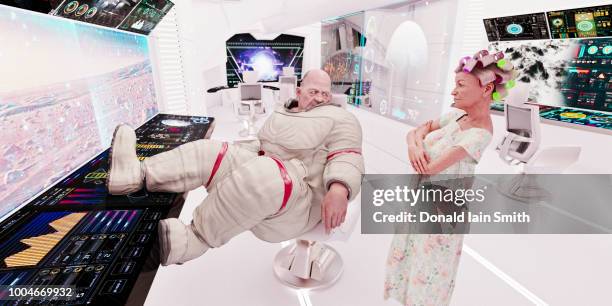 spaceship life: aging overweight astronaut and mature woman with hair curlers in control room of starship - chubby granny foto e immagini stock