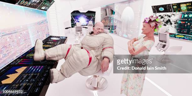 spaceship life: aging overweight astronaut and mature woman with hair curlers in control room of starship - ship's bridge imagens e fotografias de stock