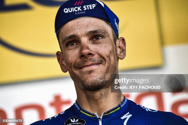 Belgium's Philippe Gilbert celebrates on the podium after receiving a prize for being the stage's most aggressive rider, following the 16th stage of...