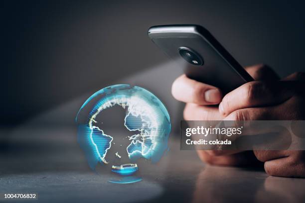 holographische projektion der erde von smartphone - smartphone hologram stock-fotos und bilder