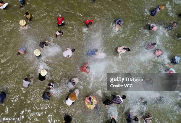 Aerial view of Miao people and tourists catching fish in a river during the Naoyu Festival at Rong'an County on July 20, 2018 in Liuzhou, Guangxi...