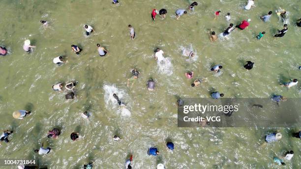 Aerial view of Miao people and tourists catching fish in a river during the Naoyu Festival at Rong'an County on July 20, 2018 in Liuzhou, Guangxi...