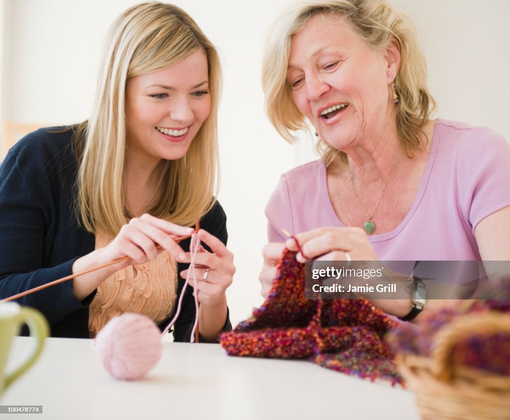Mother teaching daughter how to knit