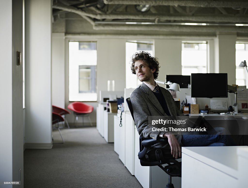 Young businessman sitting in chair in office