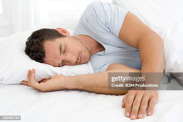 man sleeping in bed - man sleeping pillow stock-fotos und bilder