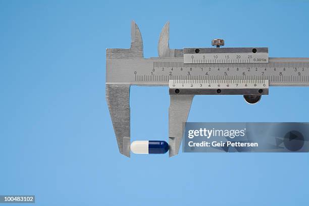 caliper measuring pill - calibrador fotografías e imágenes de stock