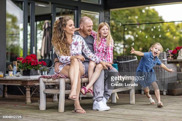 vacker mor, stilig far och två unga blonda döttrar som njuter av familjeliv i deras hus - nederländsk kultur bildbanksfoton och bilder