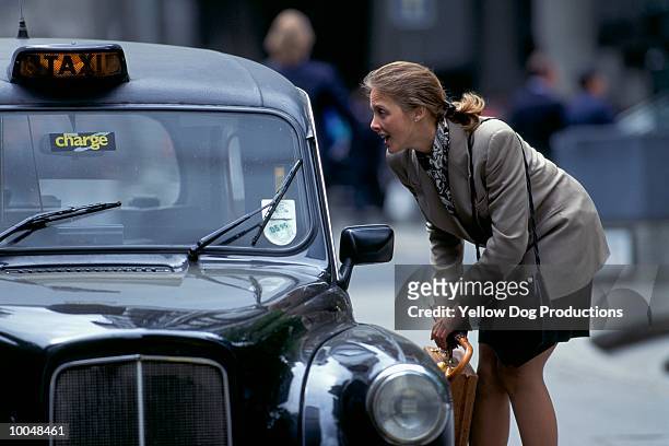 businesswoman hailing a cab in london - london taxi stock-fotos und bilder
