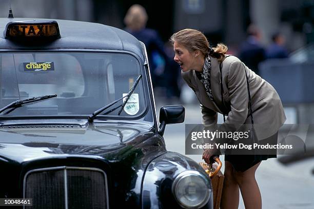 businesswoman hailing a cab in london - london taxi ストックフォトと画像