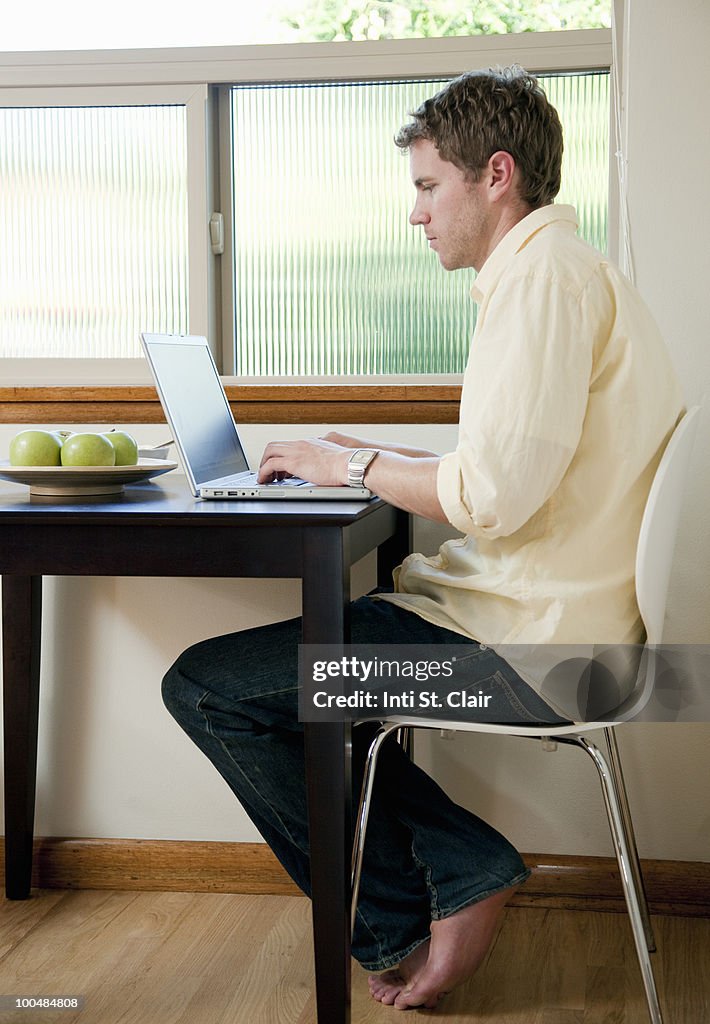Man working on laptop at breakfast
