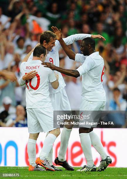 Peter Crouch of England celebrates with Ledley King and Wayne Rooney after scoring his sides second goal during the International Friendly match...