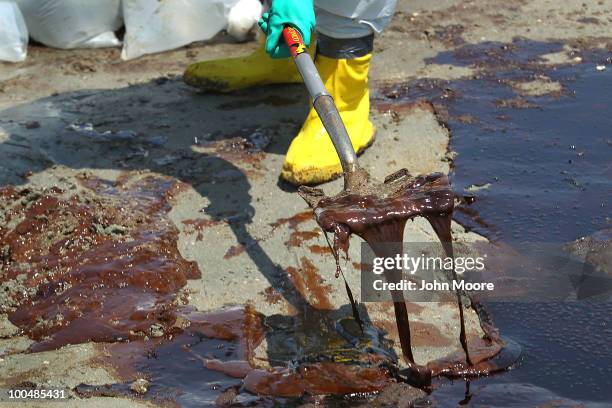 Cleanup crew shovels oil from a beach on May 24, 2010 at Port Fourchon, Louisiana. BP CEO Tony Hayward, who visited the beach, said that BP is doing...