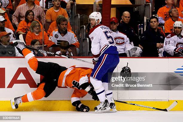 Kimmo Timonen of the Philadelphia Flyers loses his helmet while getting checked by Benoit Pouliot of the Montreal Canadiens in Game 5 of the Eastern...