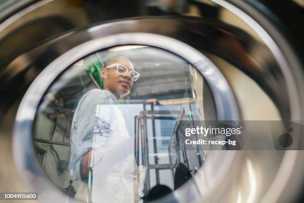african american woman working in dry cleaning shop - launderette stock pictures, royalty-free photos & images