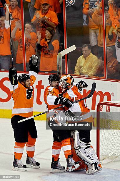Kimmo Timonen, Darroll Powe and Michael Leighton of the Philadelphia Flyers celebrate after defeating the Montreal Canadiens by a score of 4-2 to win...