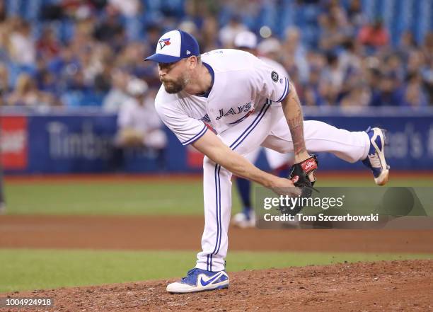 John Axford of the Toronto Blue Jays delivers a pitch in the eighth inning during MLB game action against the Minnesota Twins at Rogers Centre on...