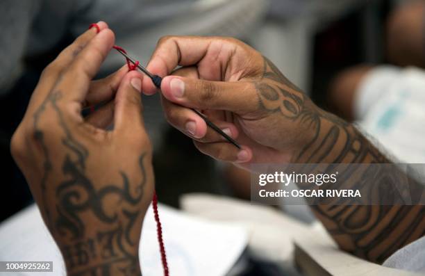 Former gang member crochets during a workshop at the prison of San Francisco Gotera, 161 km east of San Salvador on July 16, 2018. Members of two of...