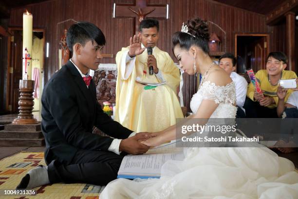 Bride and groom performing a wedding ceremony at a catholic church in Kompong Luong floating village on Tonle Sap lake.