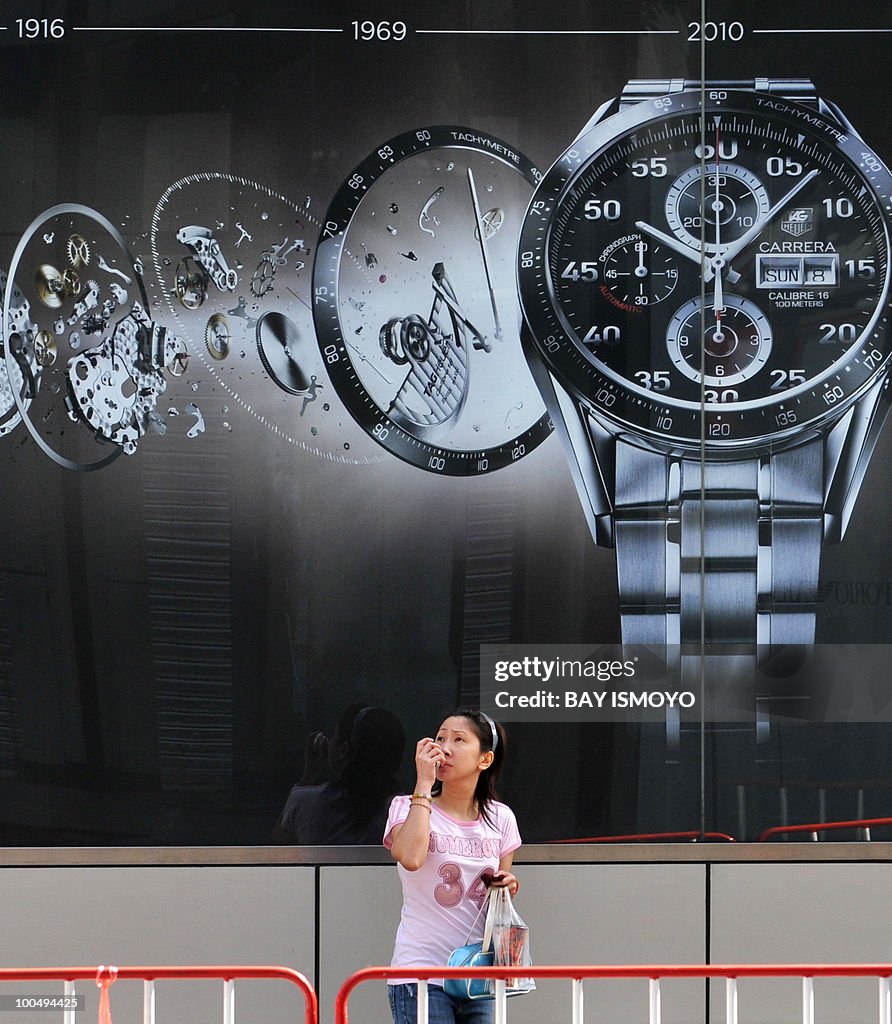 A Thai woman passes an advertisement in