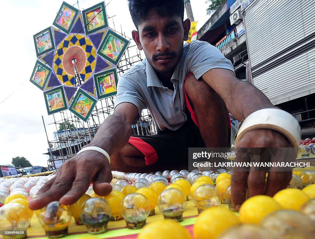 A Sri Lankan worker adjusts lightbulbs o