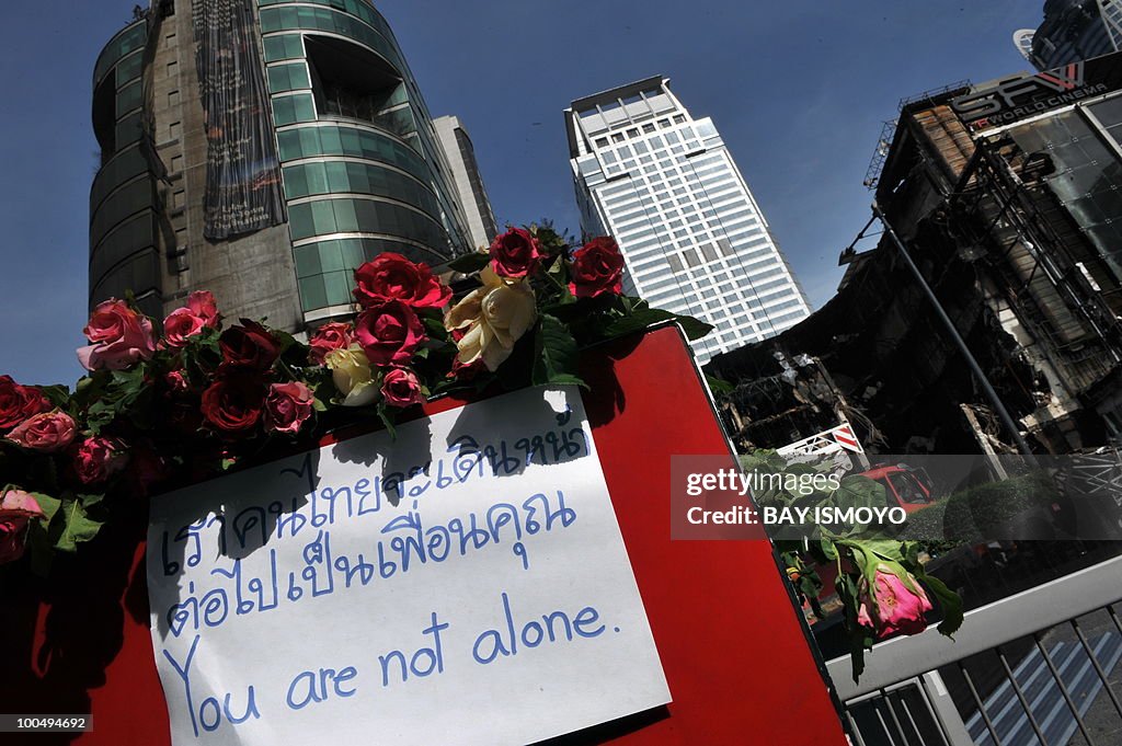 Roses and a sign stand in front of a col