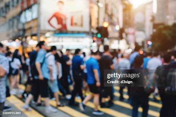 defocused image of busy commuters carrying umbrella walking on downtown city on a rainy day - causeway bay stock pictures, royalty-free photos & images
