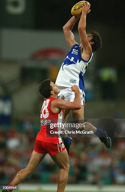 Stuart Cochrane of the Kangaroos takes a mark over Jared Crouch of the Swans during the round 4 AFL match between the Sydney Swans and the Kangaroos...