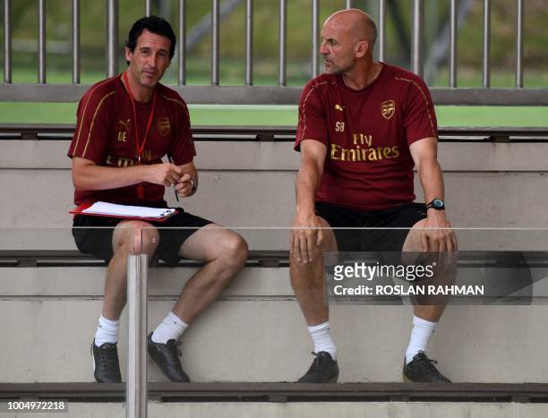 Arsenal manager Unai Emery and assistant coach Steve Bould wait for the start of the team training session during the pre-season tour for the...