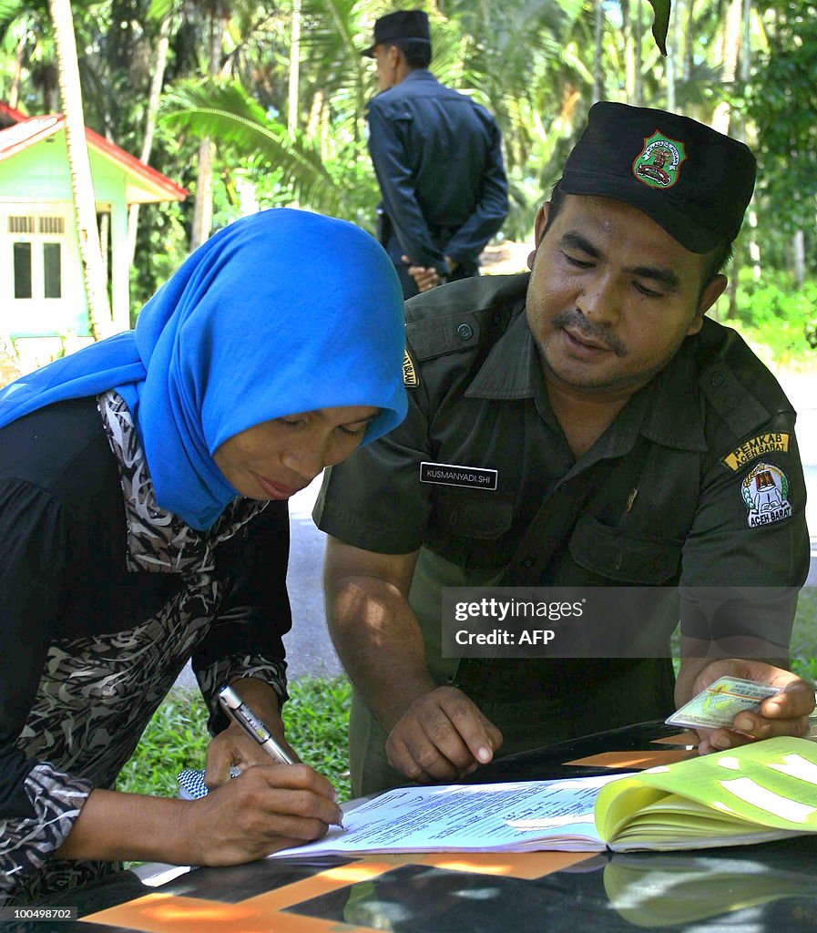 A Sharia policeman looks as a woman sign