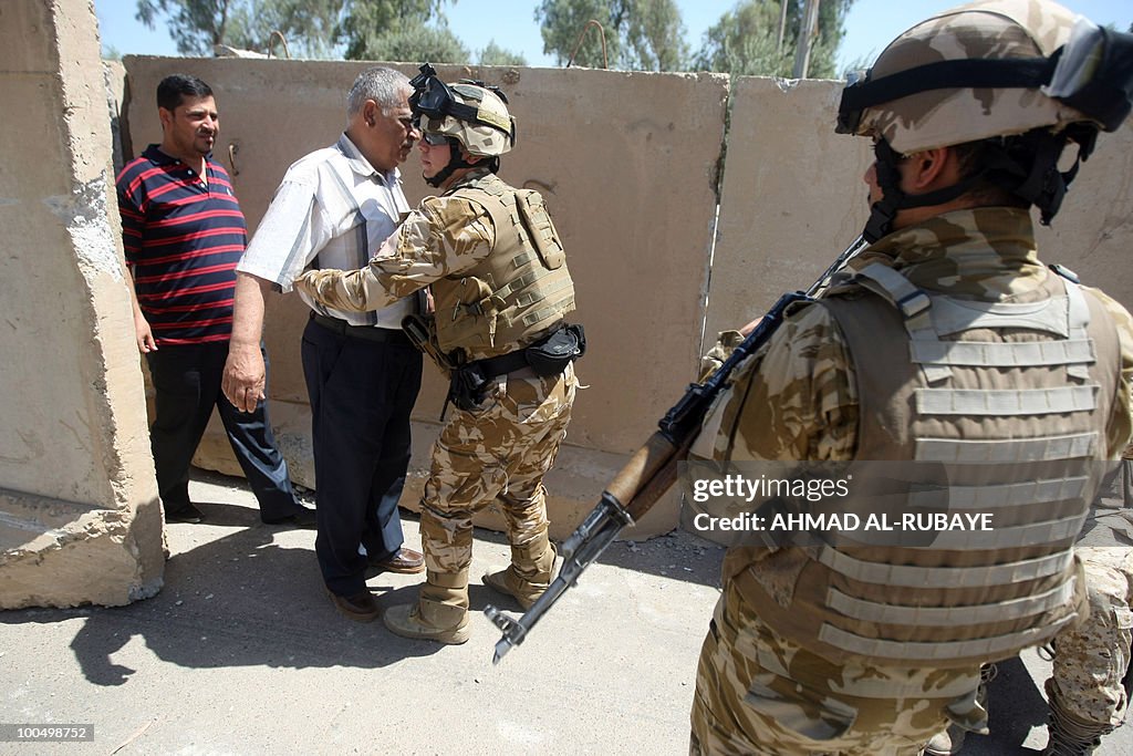 Iraqi soldiers frisk men entering the he